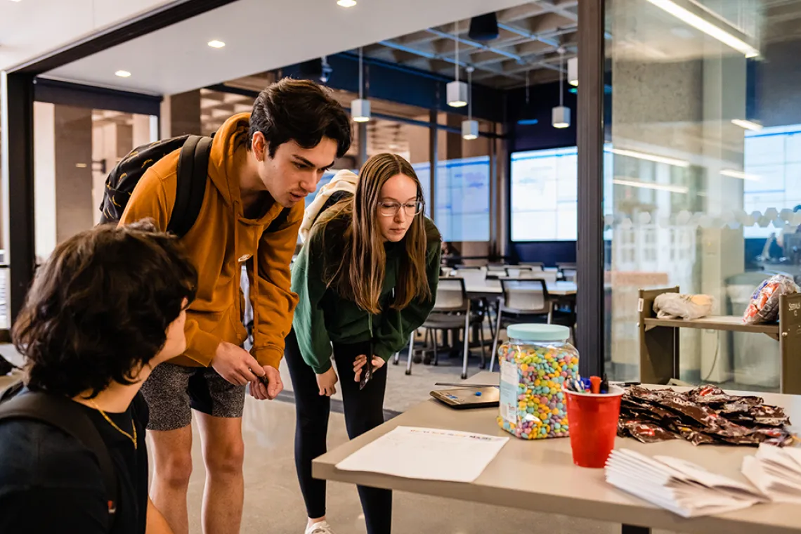 Three students try to estimate the number of M&Ms.